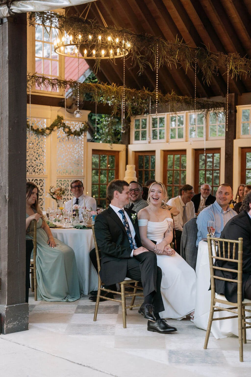Bride and Groom enjoy listening to speeches at their wedding reception