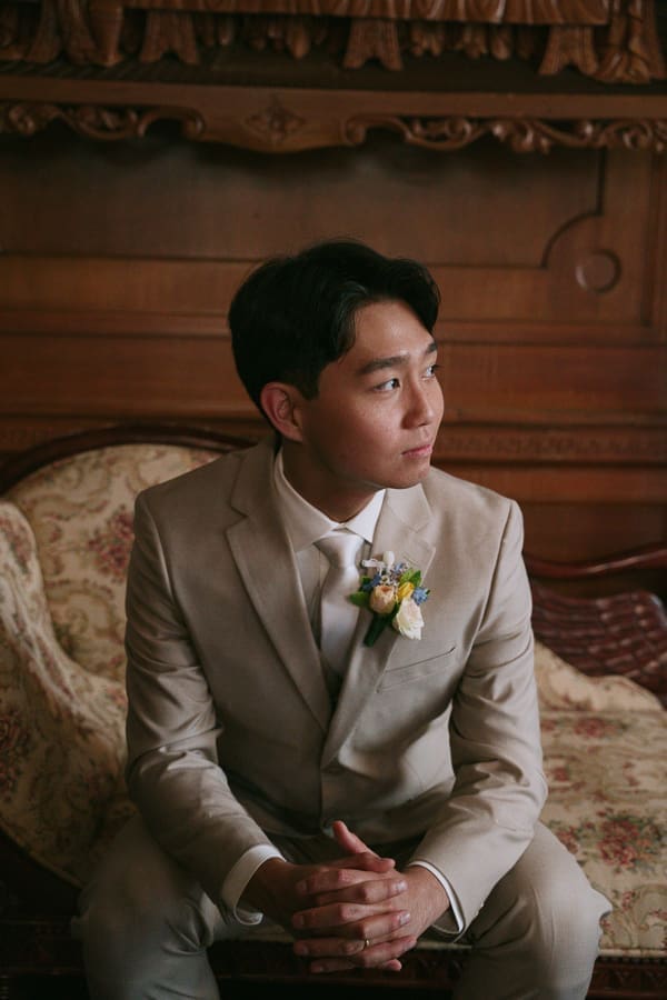 Groom sitting for a portrait inside the historic interior of Gassaway Mansion.