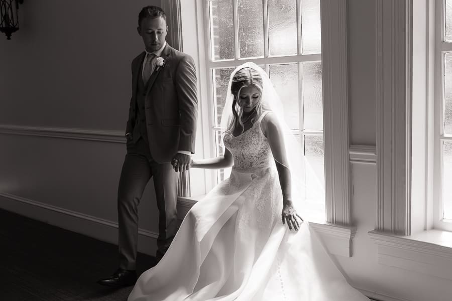 Bride sitting beside a large window during a wedding at Tate House in Tate, Georgia.