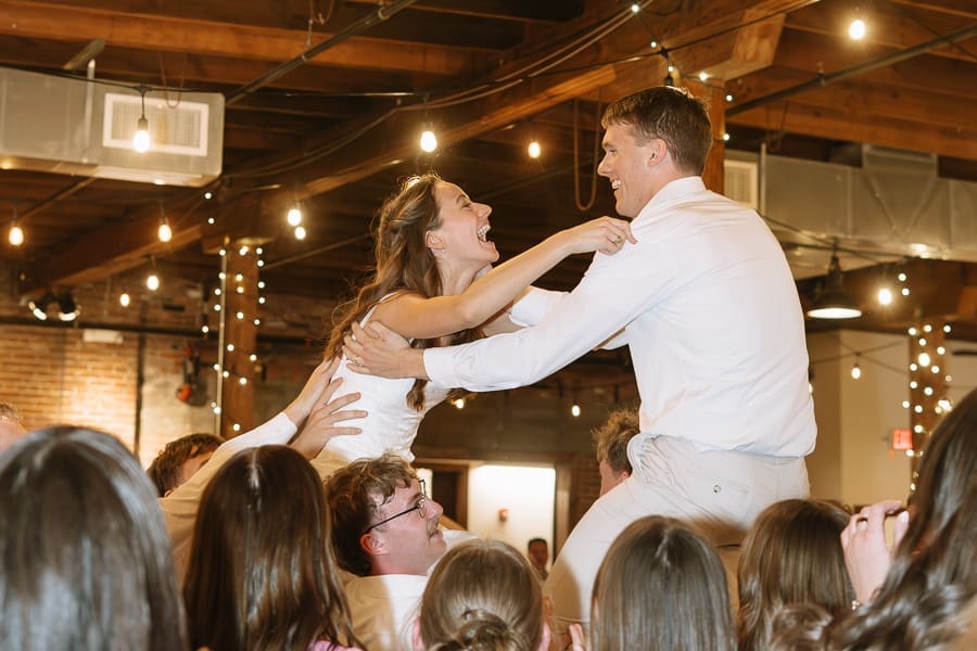 Bride and groom celebrating during their wedding reception at The Ice House on Main in College Station, Texas.