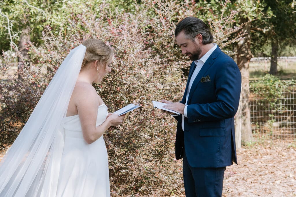 Bride and groom reading letters to one another during a first look before their Georgia wedding ceremony.