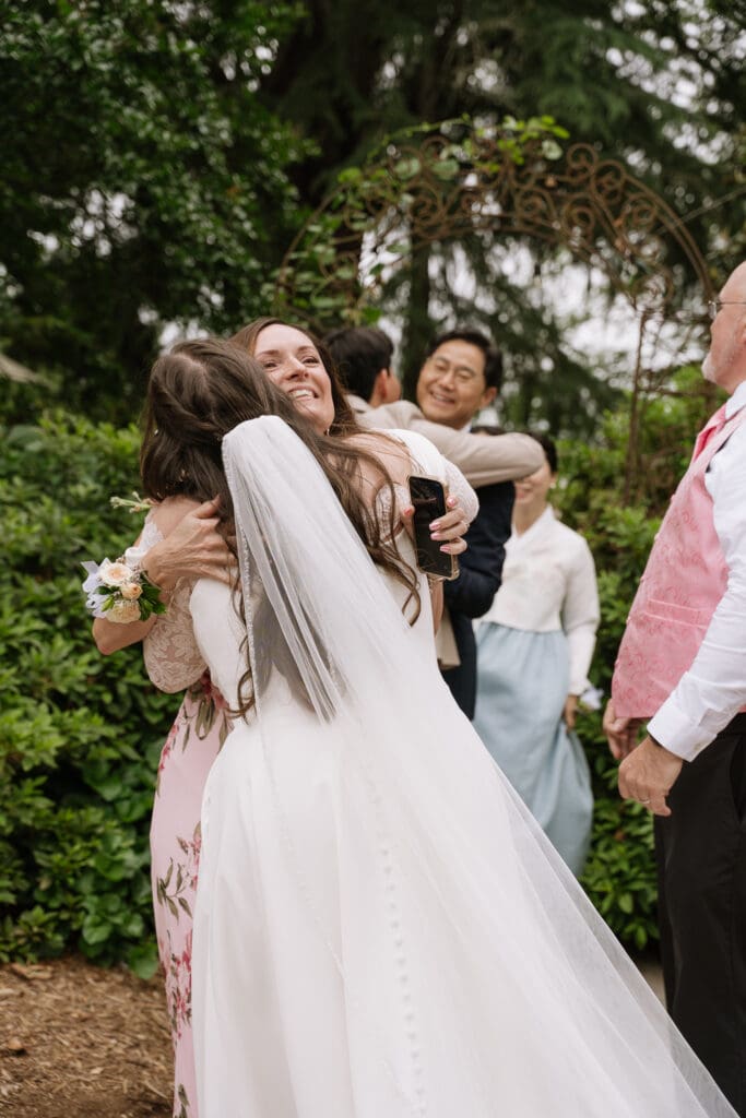 Newly married bride embracing a family member immediately after the wedding ceremony.
